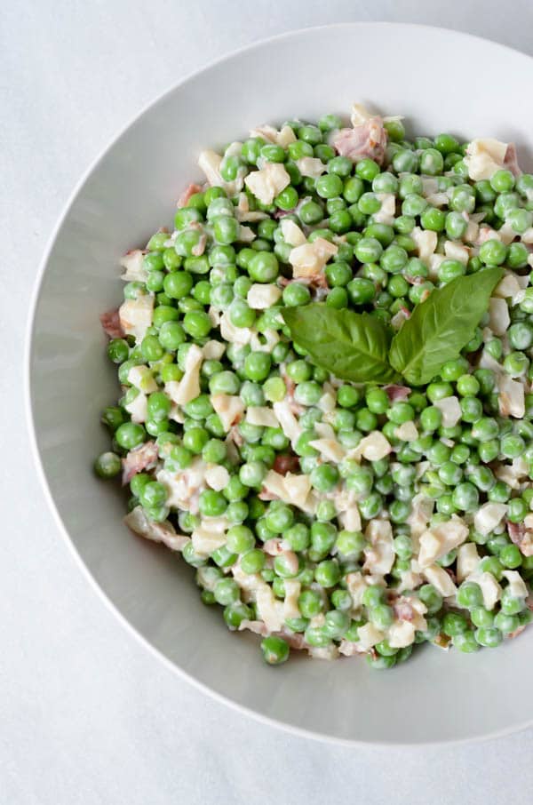Overhead shot of a bowl of pea salad garnished with basil.