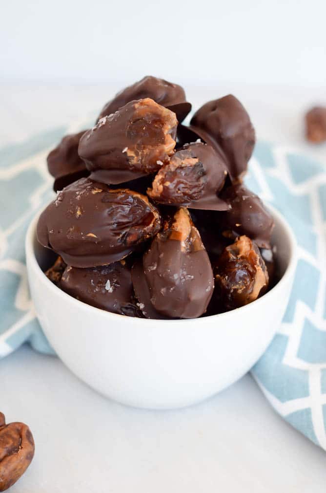 A bowl full of chocolate-covered stuffed dates.