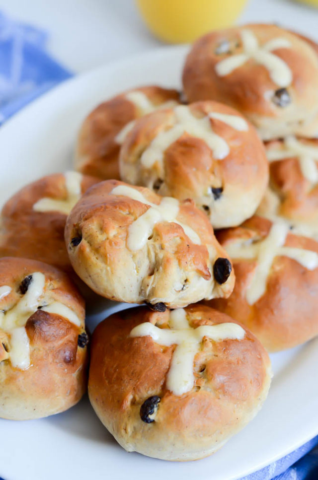 Close-up of a plate of freshly baked hot cross buns with icing.