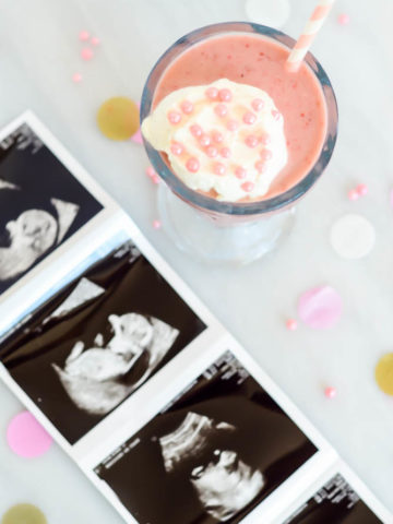 A festive pink Lightened Up Double Strawberry Milkshake with pictures from some of our baby girl's first ultrasounds!