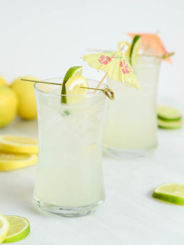 Two frosty glasses of the Hydrating Citrus Coconut Refresher mocktail. You can also make it a cocktail by adding vodka or gin!