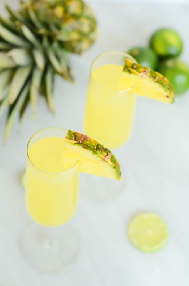 An overhead view of two delicious Tropical Pineapple Lime "Faux-mosas." Your next brunch celebration will never be the same with these mocktails!