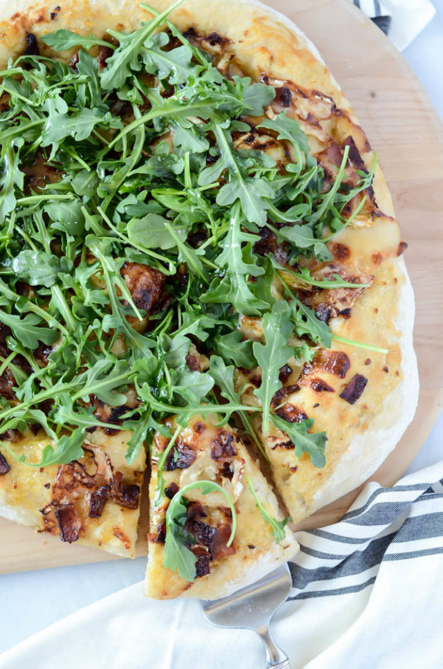 This Bacon and Goat Brie Pizza with Vanilla Passion Fruit Jam is delicious fresh out of the oven and topped with fresh arugula.