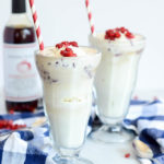 Two frosty pomegranate soda ice cream floats garnished with pomegranate seeds.