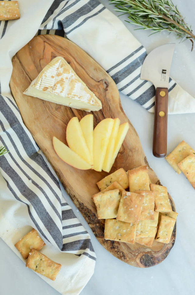 Homemade Rosemary and Olive Oil Crackers adorn a delicious cheese and fruit platter.