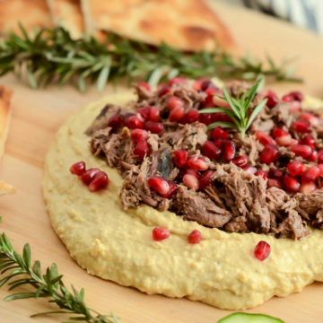 This Loaded Mediterranean Hummus Board features slow-cooked pulled lamb, pomegranate arils and refreshing sliced cucumber to make the perfect healthy appetizer for your next get-together!