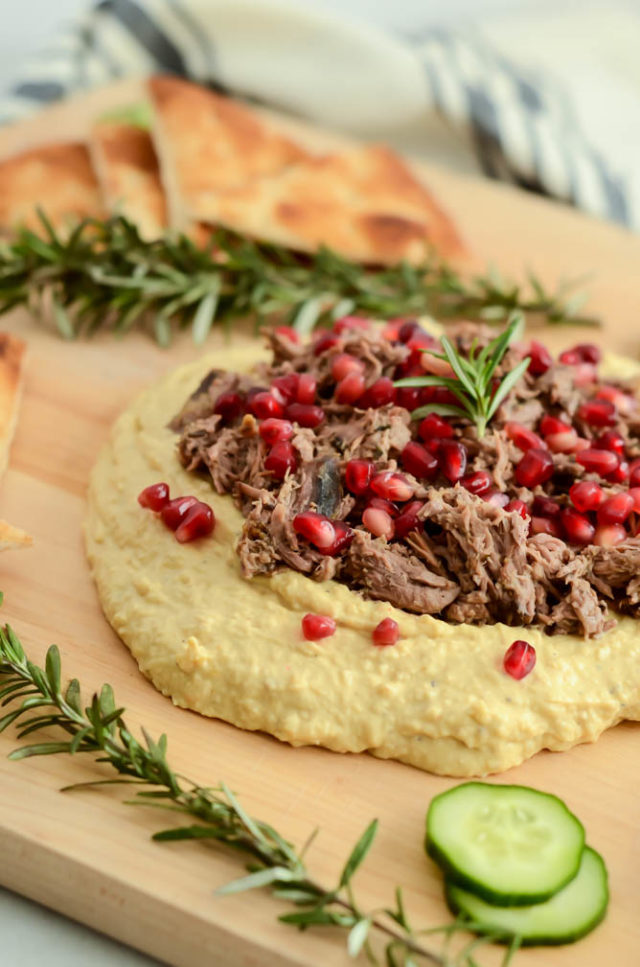 This Loaded Mediterranean Hummus Board features slow-cooked pulled lamb, pomegranate arils and refreshing sliced cucumber to make the perfect healthy appetizer for your next get-together!