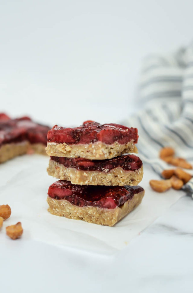 A stack of three Easy No-Bake Honey Roasted Peanut Butter and Jelly Bars.