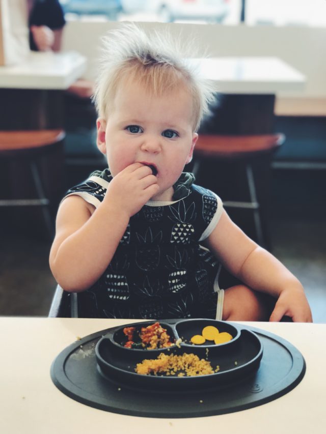 A toddler enjoying a plate full of healthy food thanks to a healthy meal prep plan.