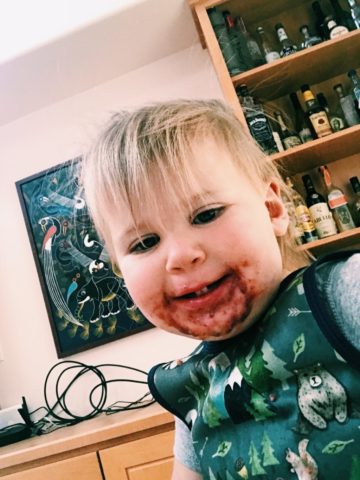 A messy-faced toddler smiling after enjoying a smoothie bowl. Smoothie bowl are a great part of meal prep!