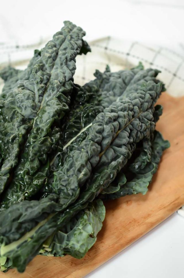 A bunch of kale on a cutting board. Kale is another great vegetable for baby-led weaning!