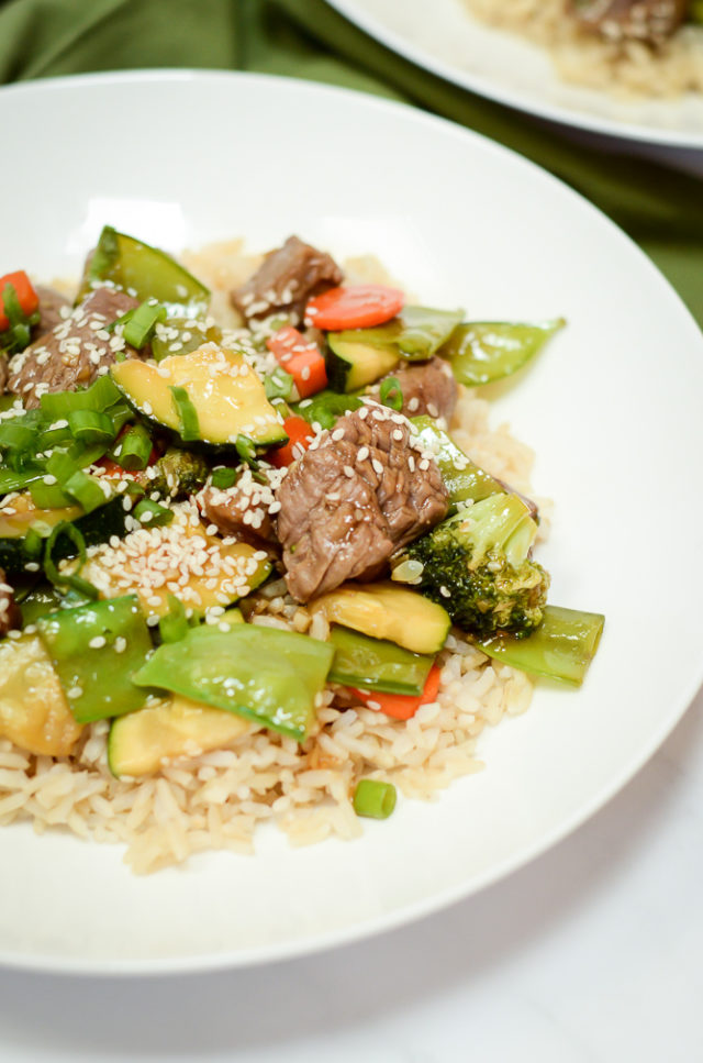 A close-up of a plate of Easy Weeknight Beef and Veggie Stir-Fry over rice.