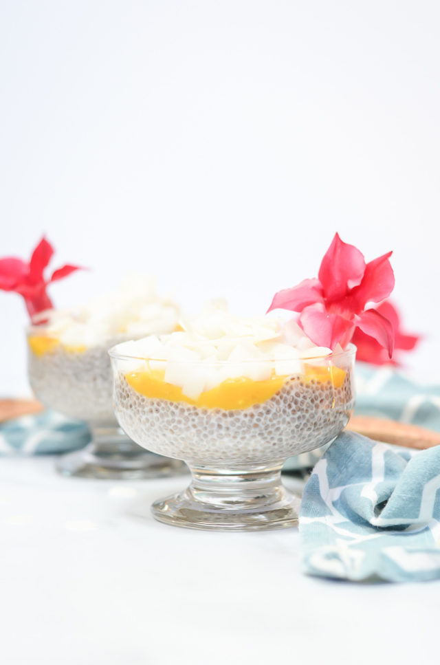 Two dishes of Coconut Passion Fruit Chia Pudding Parfait topped with pink flowers.