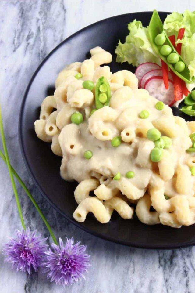 A bowl of Vegan White Bean Mac and Cheese with fresh vegetables.