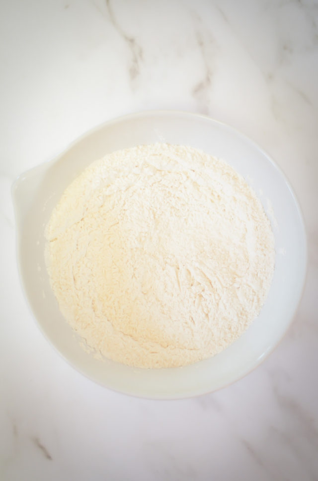 The dry ingredients for vanilla cake batter in a mixing bowl.