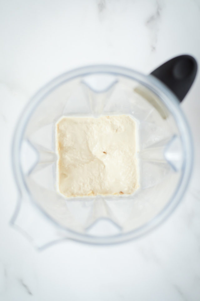 An overhead shot of cashew cream in a blender.