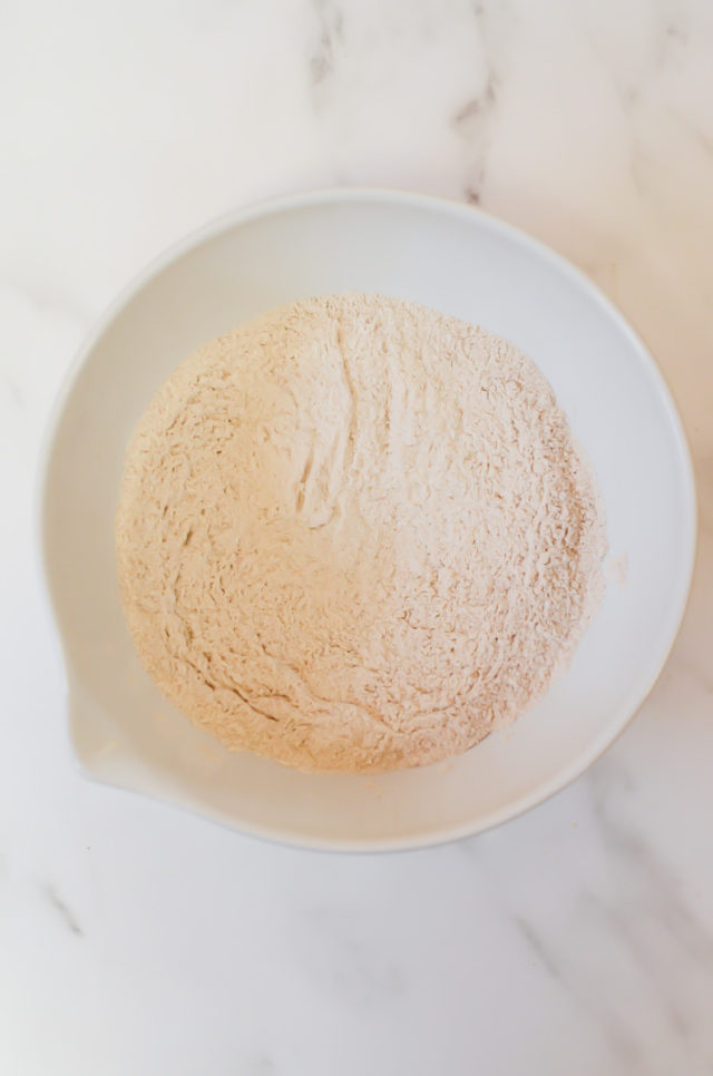 A white mixing bowl of dry ingredients.
