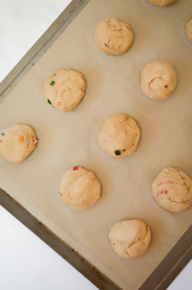 An overhead shot of a cookie sheet of hot cross buns before baking.