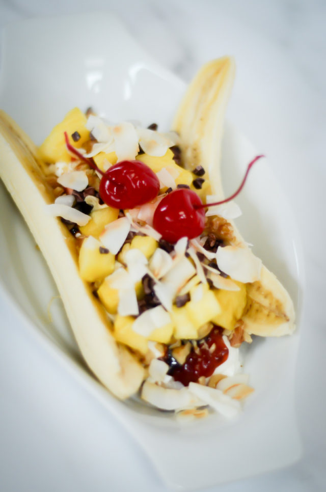 Close-up of a breakfast banana split in a white dish.