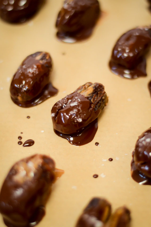 A close-up of chocolate-dipped dates sprinkled with sea salt.