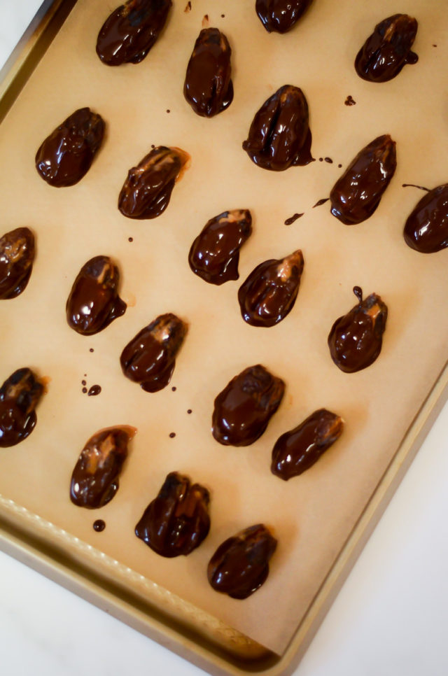 An overhead shot of a tray of chocolate-dipped stuffed dates.